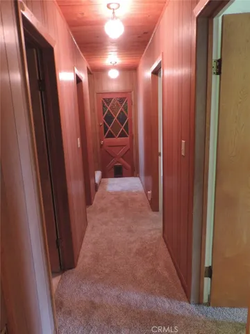 Downstairs Hallway to Lower Level Bedrooms and Full Hallway Bathroom; Stained Glass Doorway Leads to Attached Additional Storage Room