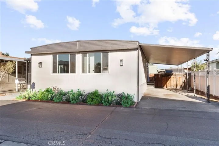 Front of home staged with flowers 3 car parking