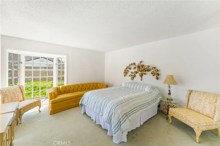Primary bedroom with sliding glass doors and bay window