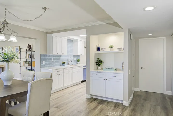Looking towards the kitchen from the dining area. The original wet bar has been updated and is now a storage cabinet with display shelves.