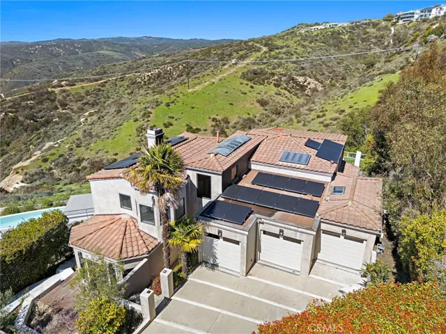 An attached three-car garage joins the driveway to offer ample parking, and owned solar, plaster interior walls, elegant modern finishes and top-tier craftsmanship offer enduring value.