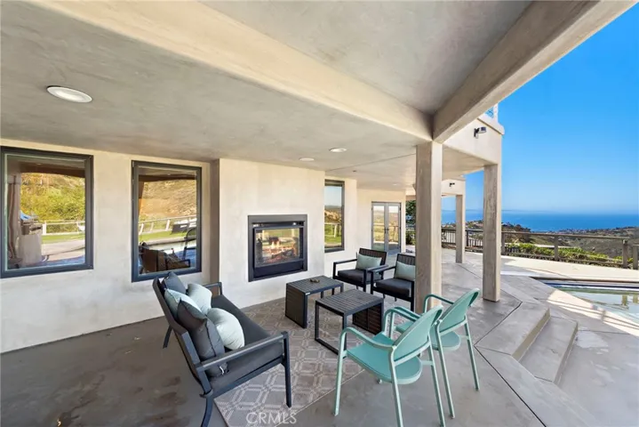 This level opens to a deck spanning approximately 1,500 square feet with a swimming pool, wood-lined sauna and stunning views.