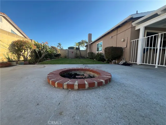 in ground fire pit and 1 of 2 grass areas of the backyard