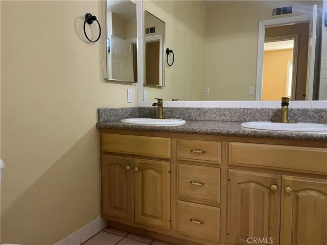 2nd bathroom with dual sinks and shower tub