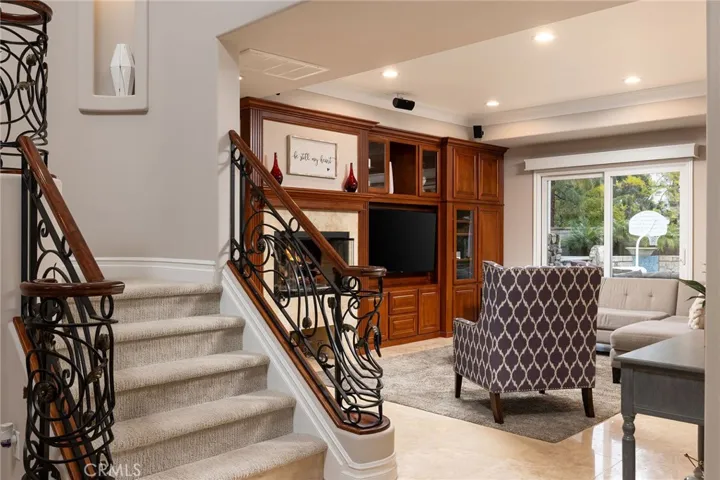 Family room with built- in entertainment center and gas fireplace, travertine floors, custom shades