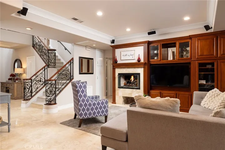 Family room with built- in entertainment center and gas fireplace, travertine floors,