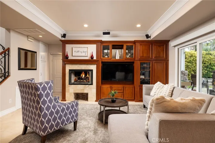 Family room with built- in entertainment center and gas fireplace, travertine floors,