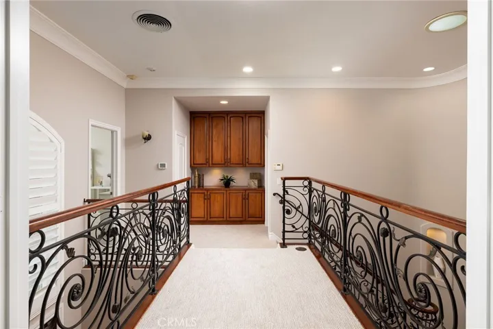 Catwalk with custom railing separate primary suite from secondary bedrooms