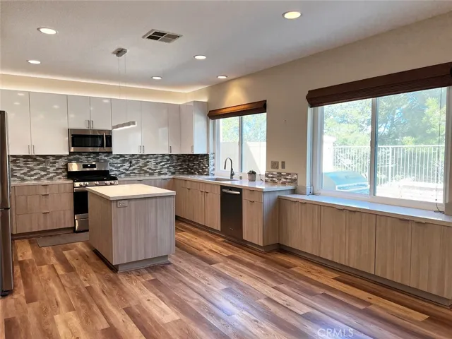 Remodeled two tone chef's kitchen with white oak and white cabinetry and an island