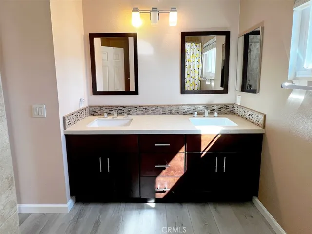 Upstairs secondary bathroom with dual sinks, espresso cabinets, tub in shower