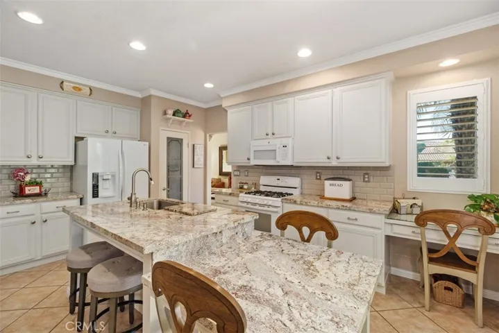 Beautifully Honed Granite Countertops, Farm-style Sink, Walk-In Pantry, Desk Space and Seating for Five Complete this Open Kitchen.