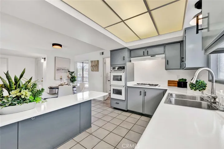 Kitchen Open to Dining Room with Wrap-Around Breakfast Bar and Tile Flooring