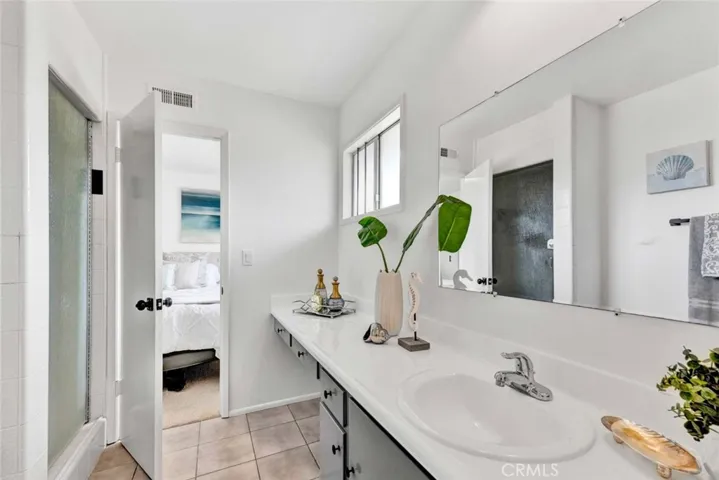 Jack & Jill Bathroom with Resurfaced Countertop, Sit-Down Vanity and Tiled Shower