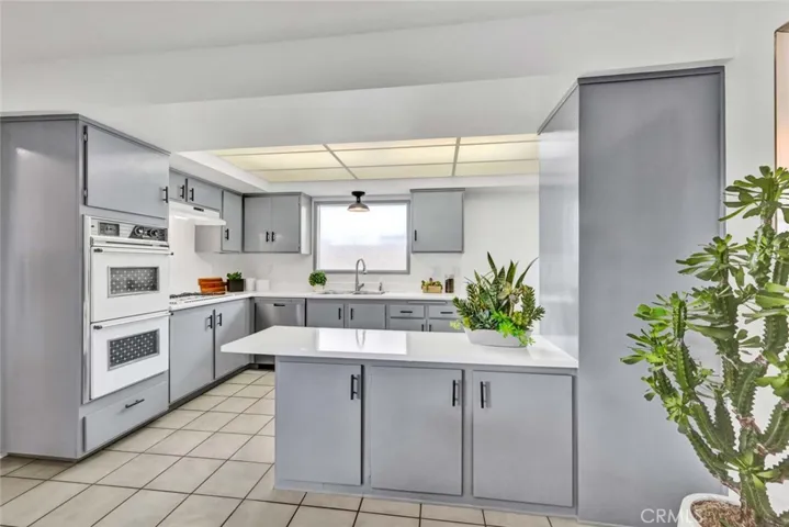 Charming Kitchen: New Paint, Resurfaced Counters, Tile Flooring, Breakfast Bar, Double Ovens, Stainless Sink, Gas Cooktop, Vent/Hood, Stainless Dishwasher