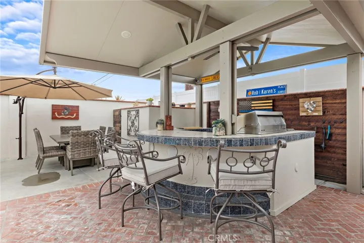Entertain with ease at the covered BBQ island, equipped with a built-in BBQ, refrigerator, and lighting.