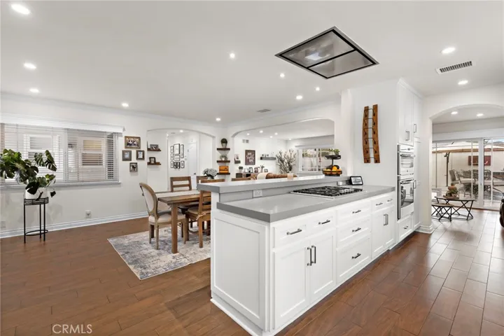 The chef’s gourmet kitchen is a dream, boasting quartz countertops, a designer marble backsplash extending to the ceiling, custom cabinetry with large drawers and pull-outs