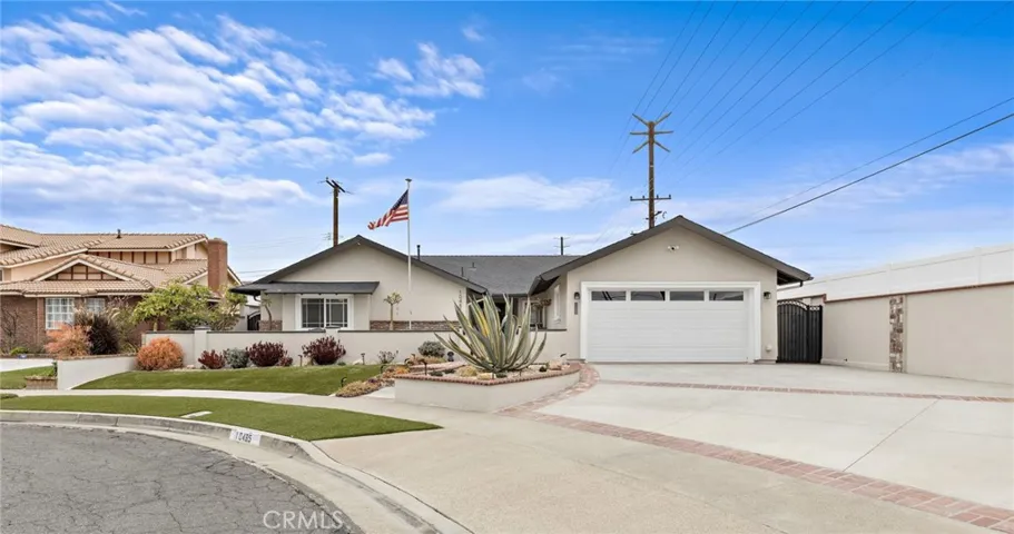 This sprawling single-story home is a true gem, offering both elegance and comfort. A beautifully curved driveway with brick ribbon accents leads to the front gated courtyard, surrounded by artificial grass and a charming succulent garden