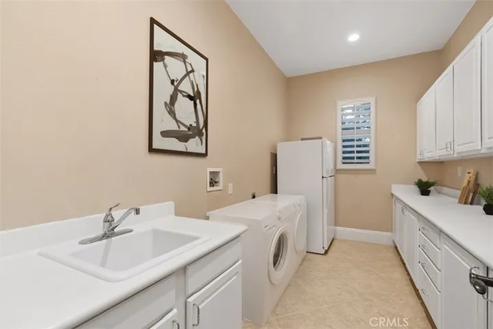 Laundry room with sink and built-in cabinets