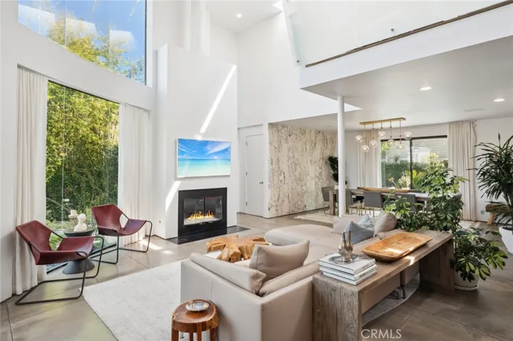 This exceptional residence boasts soaring ceilings, walls of glass, and polished concrete floors, creating an open and airy ambiance that seamlessly blends indoor and outdoor living.