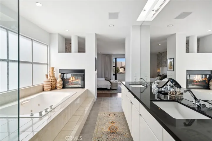 The primary suite is a serene retreat, complete with a private balcony overlooking the mountains, a double-sided fireplace, and a spa-inspired bathroom with oversized shower.