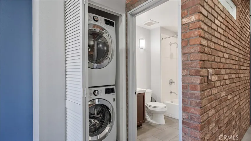 Off dining area full size stackable washer and dryer.