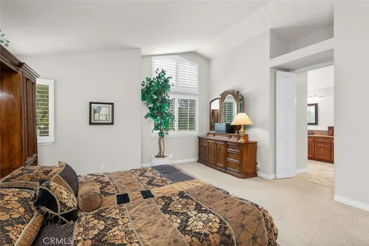 Primary bedroom looks out onto the large backyard and also offers double doors to the primary bathroom.