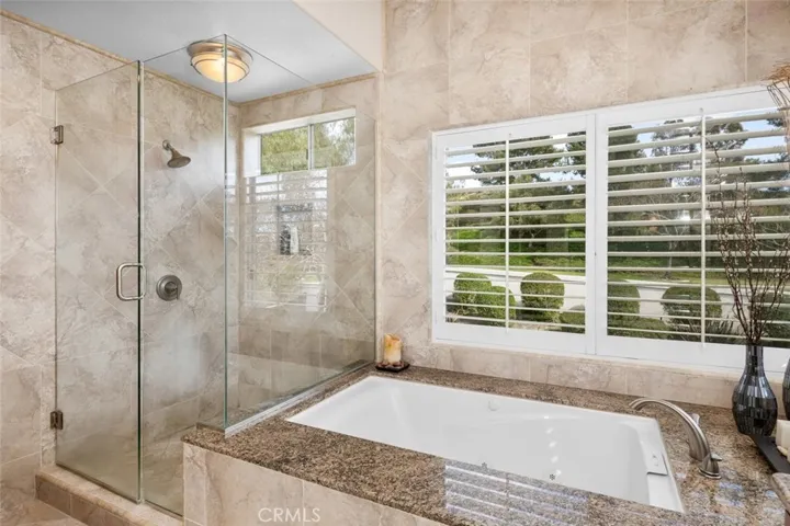 Both shower and tub with natural views.