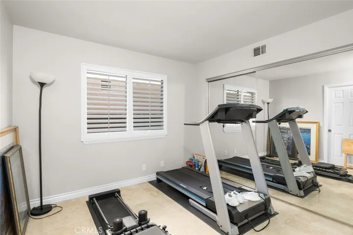 Main floor bedroom has large mirrored wardrobe, plantation shutters and even a pocket door to the full bath downstairs creating more of a en suite when you have guests.