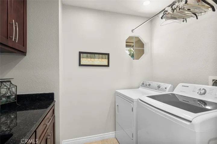 Large laundry room with custom counter top, inset large sink and great cabinetry to match the kitchen cabinets.
