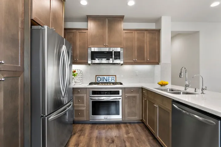 5 burner gas cooktop, stainless oven, microwave, and fridge