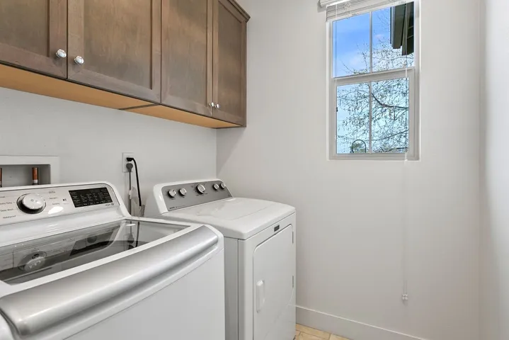 Second level laundry room with storage and window