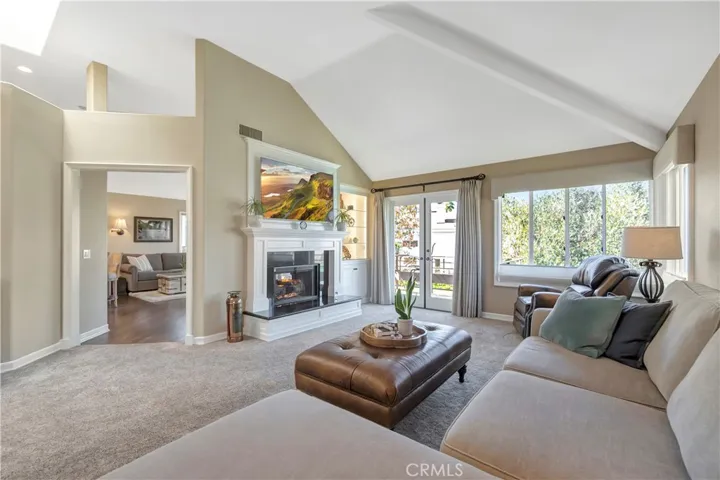 The formal living room  has dry bar and a double-sided fireplace that looks through to the family room
