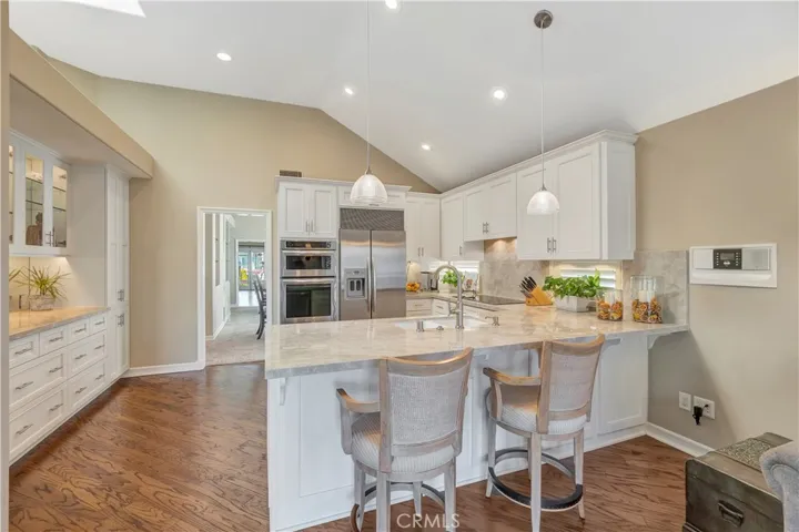 Beautifully remodeled kitchen with quartzite counter tops, stainless steel appliances and ample cabinet and counter space