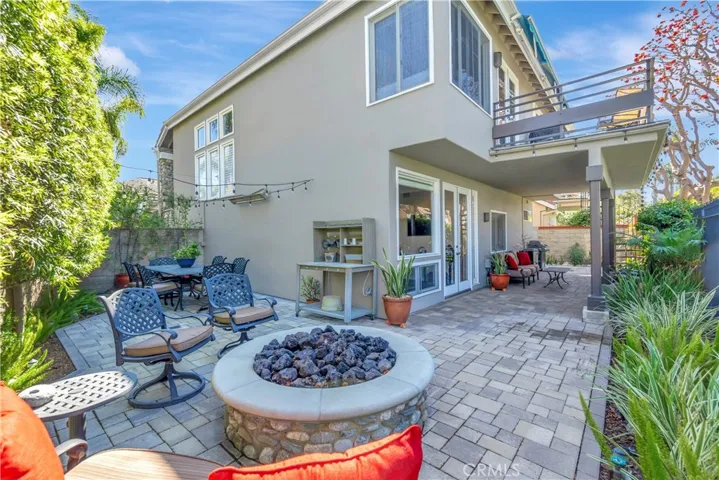 Custom outdoor paver backyard with an inviting firepit and eating area all with direct access to the community green belt and tennis/pickle ball courts