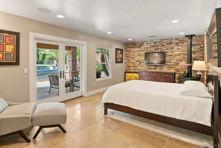 This downstairs bedroom is plumbed for a bar or kitchenette if you want to convert this room to a poolside lounge, maid's room, or senior quarters. A pellet-fueled fireplace sits in the far corner.