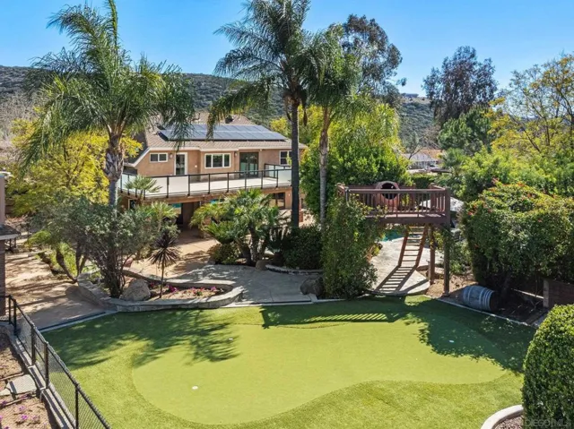 This photo shows the putting green in the foreground and the staircase to the tube slide into the pool in the background.