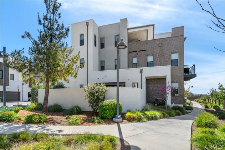 This property features a modern architectural design, well-maintained landscaped grounds, corner location, and ample parking for residents and visitors