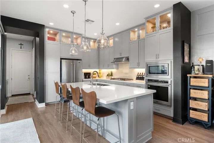 Spacious kitchen layout with abundant natural light, modern appliances, an open concept design, and sleek cabinetry.