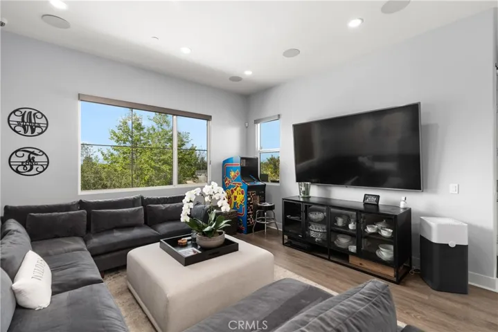 Spacious living room features a bright, open layout with abundant natural light and vinyl wood flooring.