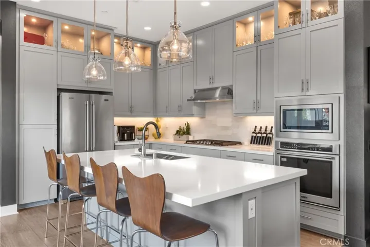 Spacious kitchen layout with abundant natural light, modern appliances, an open concept design, and sleek cabinetry.