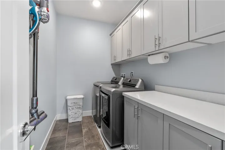 Laundry room features ample storage space and tile flooring.