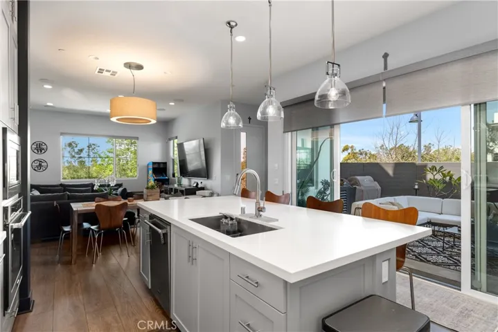 Spacious kitchen layout with abundant natural light, modern appliances, an open concept design, and sleek cabinetry.
