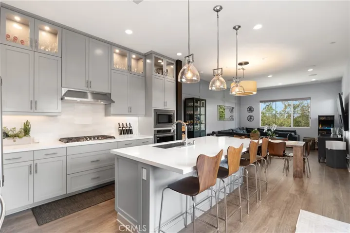 Spacious kitchen layout with abundant natural light, modern appliances, an open concept design, and sleek cabinetry.