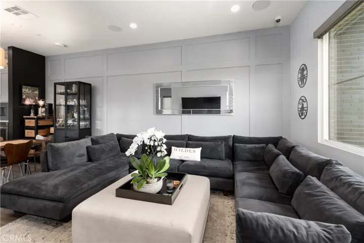 Spacious living room features a bright, open layout with abundant natural light, decorative wall finish and vinyl wood flooring.
