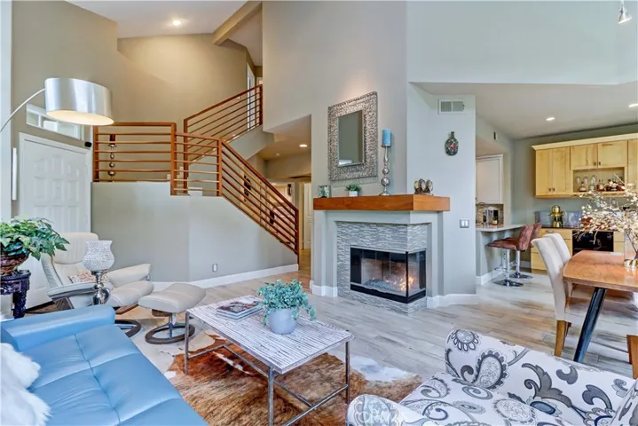 The staircase has been remodeled by removing high, curved drywall and opening it up with a custom solid walnut banister.  Solid walnut fireplace mantle to match.