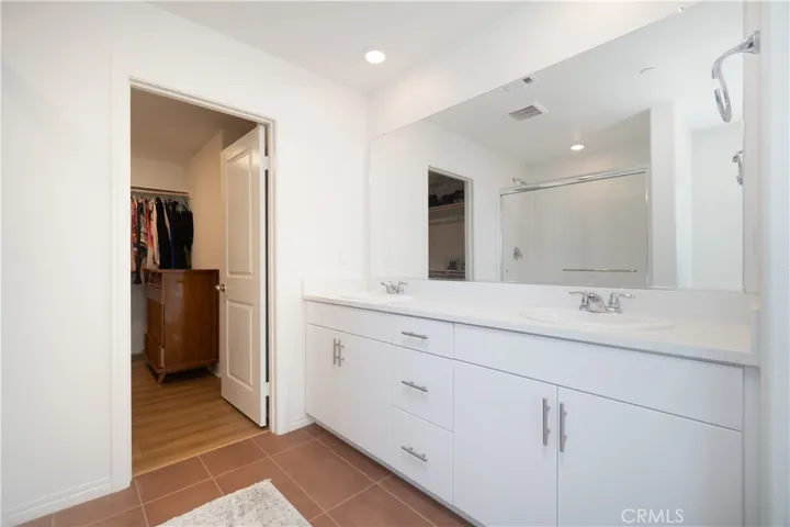 Detail of the dual sink vanity and entry to the walk-in closet