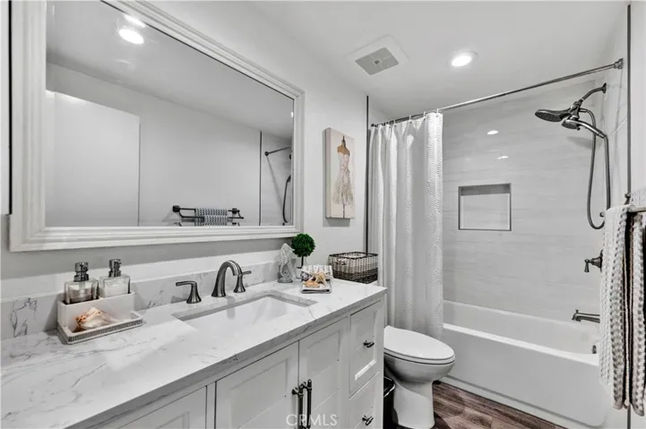remodeled guest bathroom with a tiled tub/shower combo featuring multiple showerheads