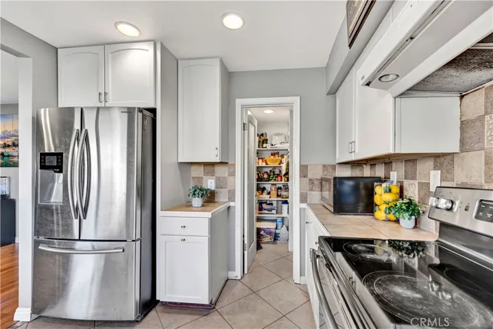 spacious kitchen is a chef’s delight, featuring a full walk-in pantry