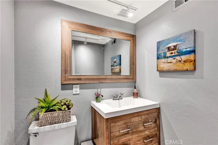 newer vanities, Quartz countertops, wood-look vinyl flooring, and updated mirrors and fixtures