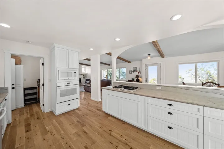 Both Kitchens Showcase Custom-Built Cabinetry, Quartz Countertops, Farmhouse Sinks, And High-End Finishes